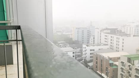 balcony view of bangkok city with monsoon rainstorm and apartments in the background