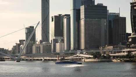 Medium-view-of-a-CityCat-and-Brisbane-City-in-the-afternoon-light,-Queensland,-Australia