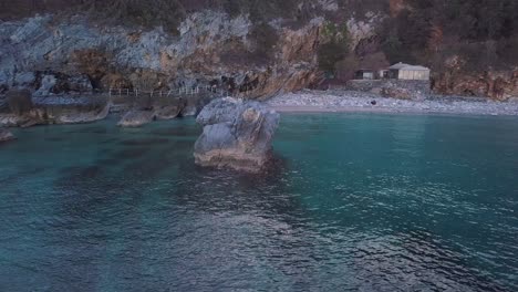4K-Luftaufnahmen-Mit-Schneller-Umlaufender-Drohne-Eines-Großen-Felsens-Im-Kristallklaren-Wasser-Des-Meeres-In-Griechenland