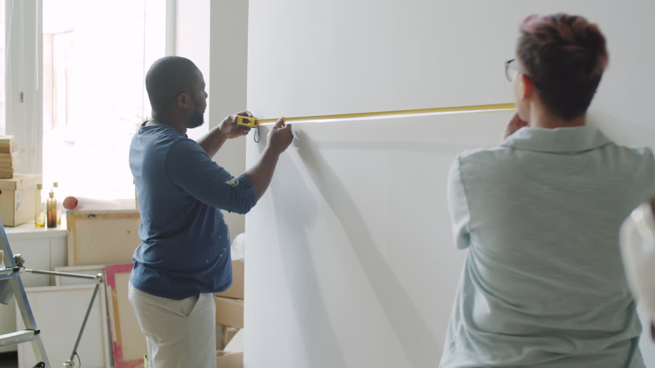 Couple Measuring Wall for Renovation