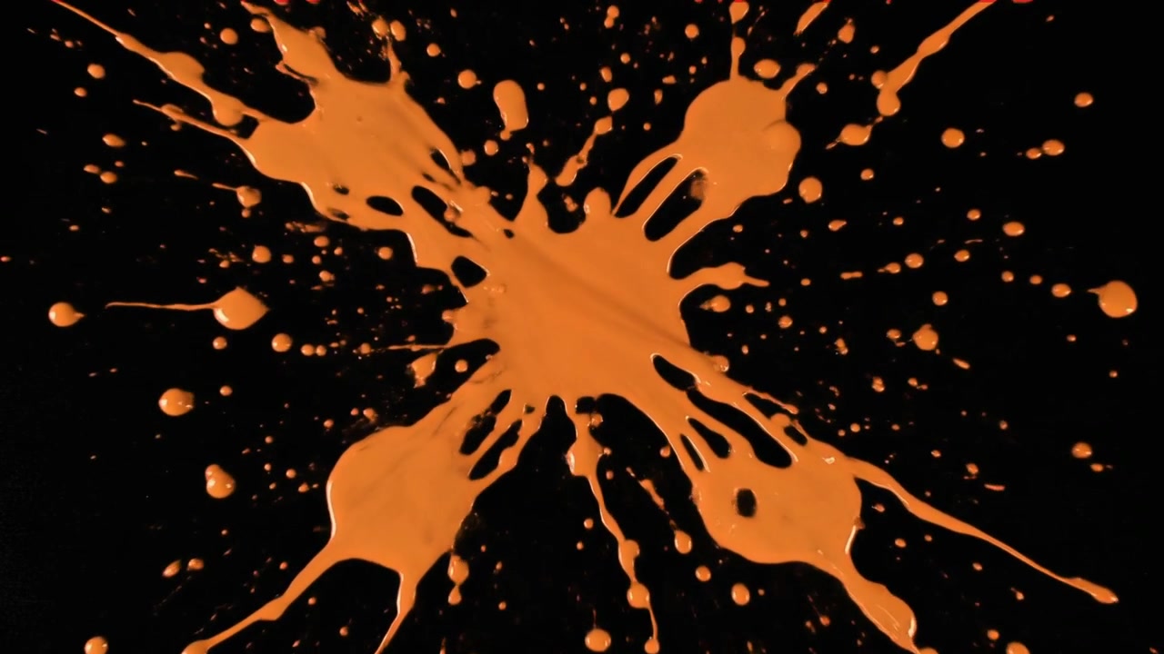Orange maling sprøjter på sort baggrund