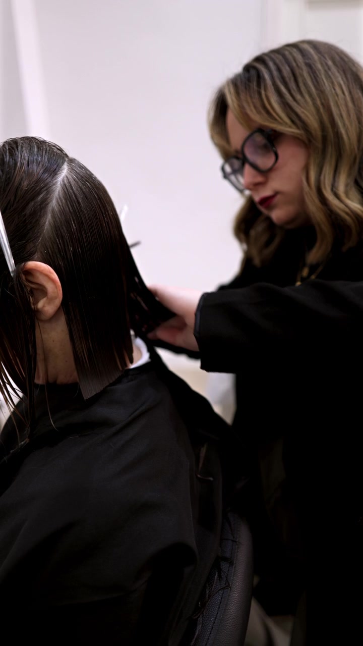 Parrucchiere professionista che taglia i capelli a un cliente in salone