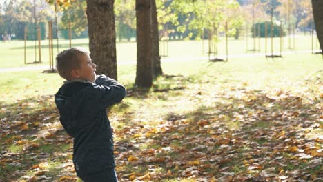 Un-Niño-En-El-Colorido-Parque-De-Otoño-Juega-Con-Un-Avión-De-Papel