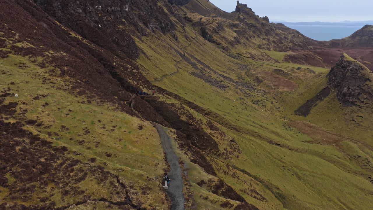 Folk som går tur på en fjellsti i Quiraing på Isle of Skye