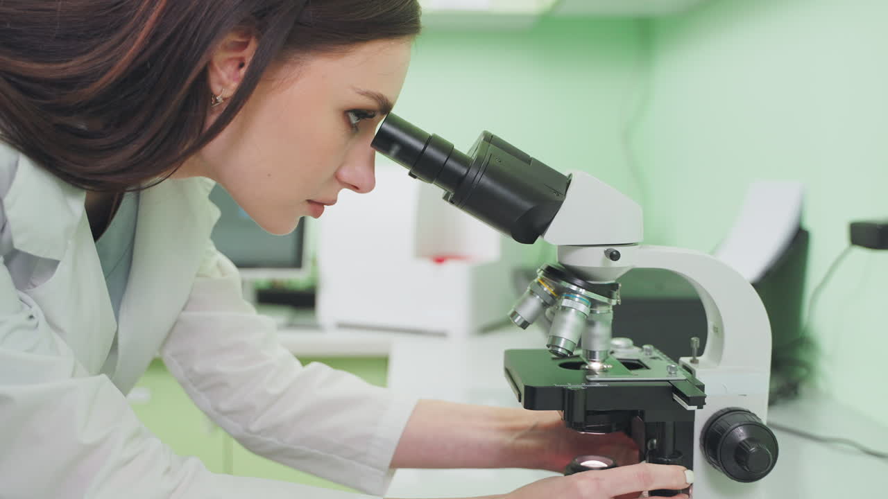 Female Scientist Using Microscope in Laboratory