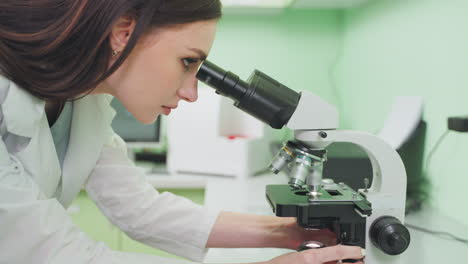 female scientist using microscope in laboratory