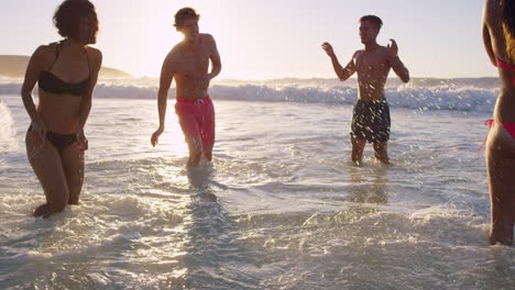 Eine-Vielfältige-Gruppe-Von-Freunden-Schwimmt-Bei-Sonnenuntergang-Im-Meer