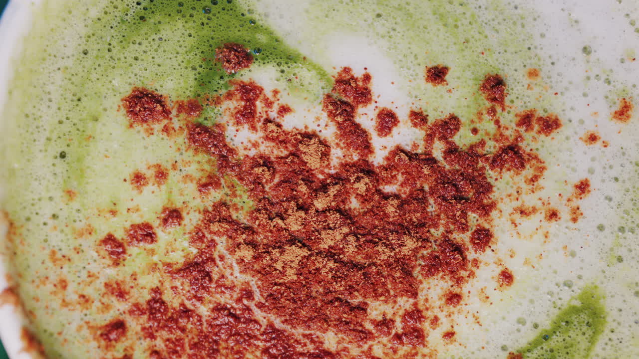 Close up of matcha a latte with cinnamon sprinkled on the foam