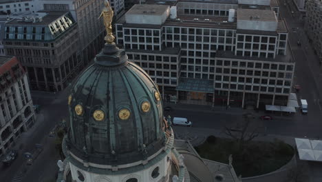 AERIAL:-Close-Up-Drone-View-of-Cathedral-Tower-Roof-and-Golden-Statue-on-top-in-Berlin,-Germany-at-Sunset