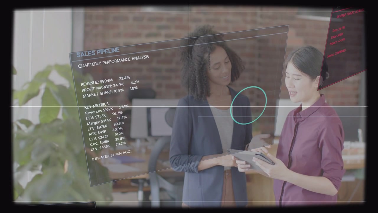 Woman with tablet tapping, updating sales HUD and pulsing reticle while coworker reviewing pipeline