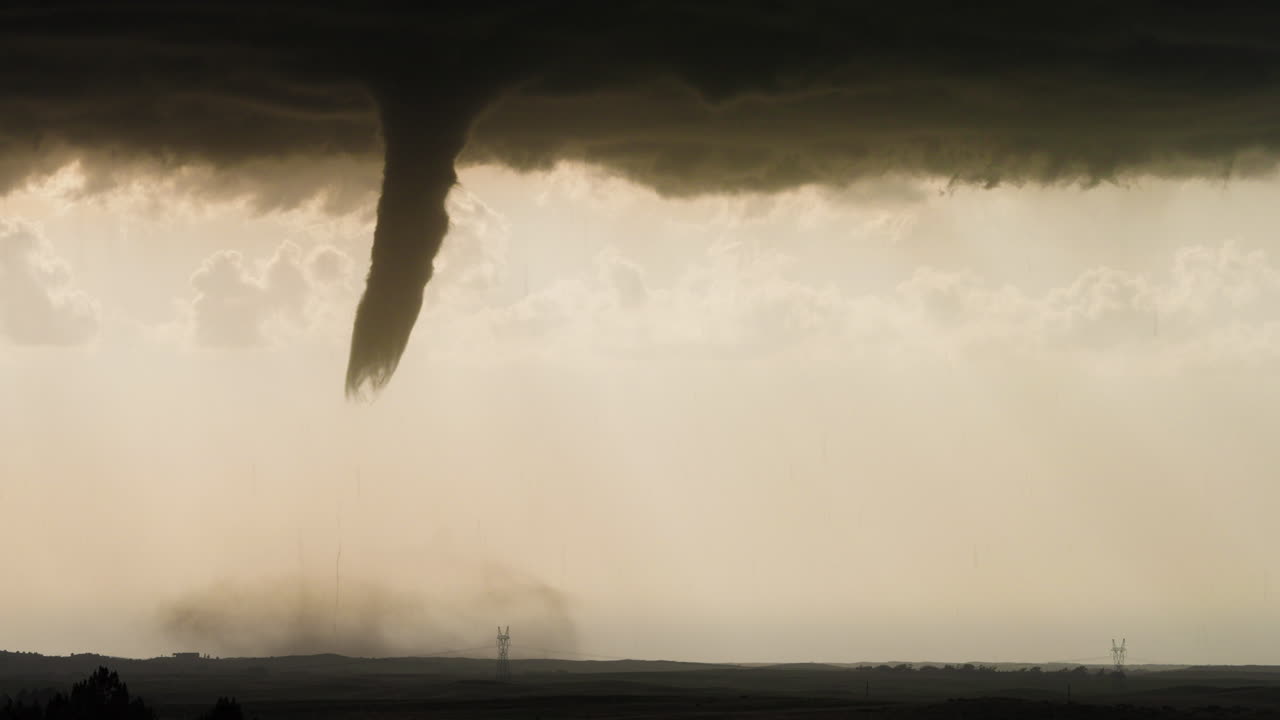 Tornado Under Supercell Thunderstorm with Lightning in Distance