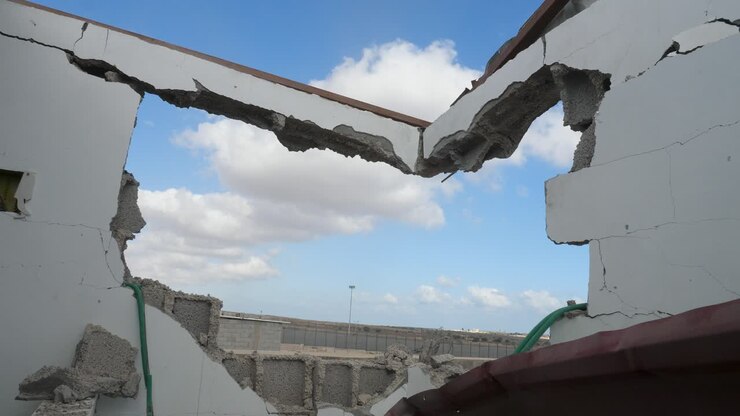 Bombed building wall in Israel-Hamas war conflict under clear blue sky