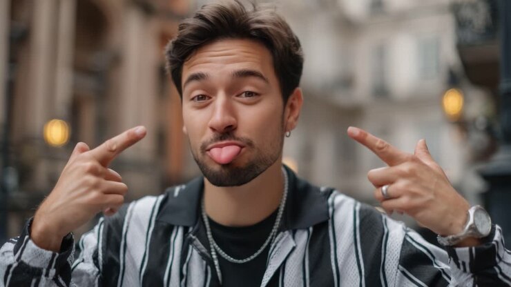 A Young Man Displays a Playful Expression in an Urban Setting, Transitioning from a Fun Gesture to a Thoughtful Look Amidst a Cityscape Background