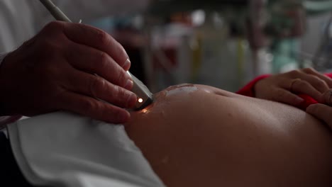 médico ginecólogo realizando un examen de ultrasonido en una mujer embarazada. vientre de cerca
