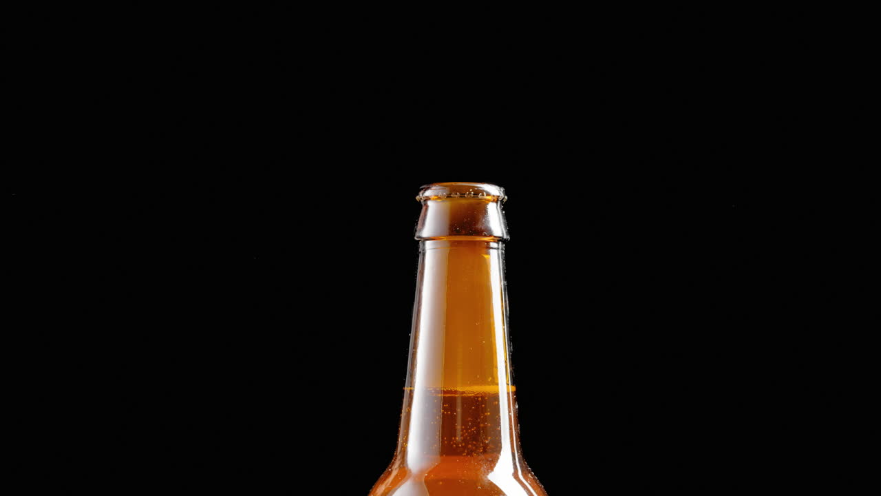 Using a bottle opener to take the cap off a bottle of beer - vapor released