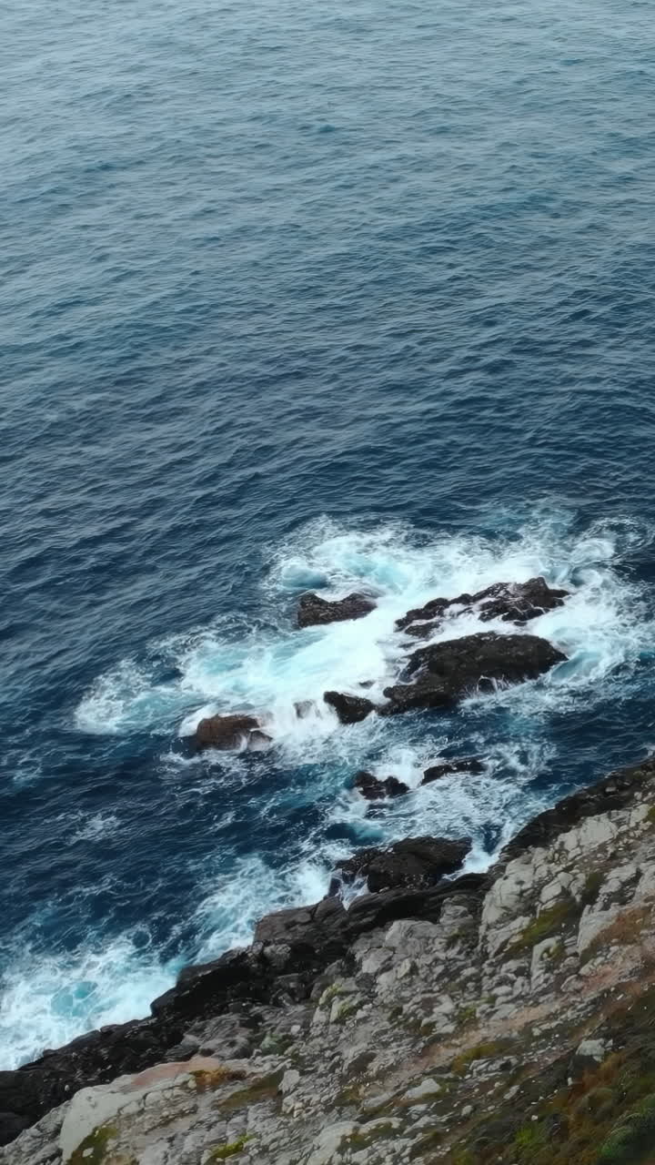 Vista aerea di onde che si infrangono su una costa rocciosa frastagliata