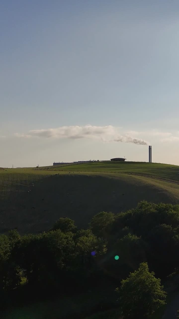 Industrial Factory with Smoking Chimneys in a Green Rural Landscape