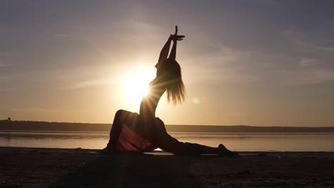 Silhouette-Einer-Schönen-Yoga-Frau-Am-Morgenhimmel-An-Einem-Meeresstrand.-Eine-Frau,-Die-Yoga-Virabhadrasana-II-Krieger-II-Pose-Praktiziert.-Meditationsposition-Vor-Dem-Meer-Bei-Sonnenaufgang