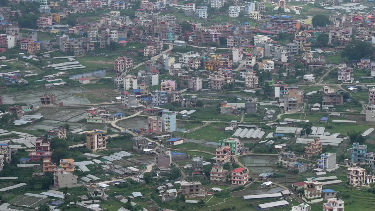 A panning aerial view of the city of Kathmandu, Nepal on a cloudy day at the beginning of rainy season
