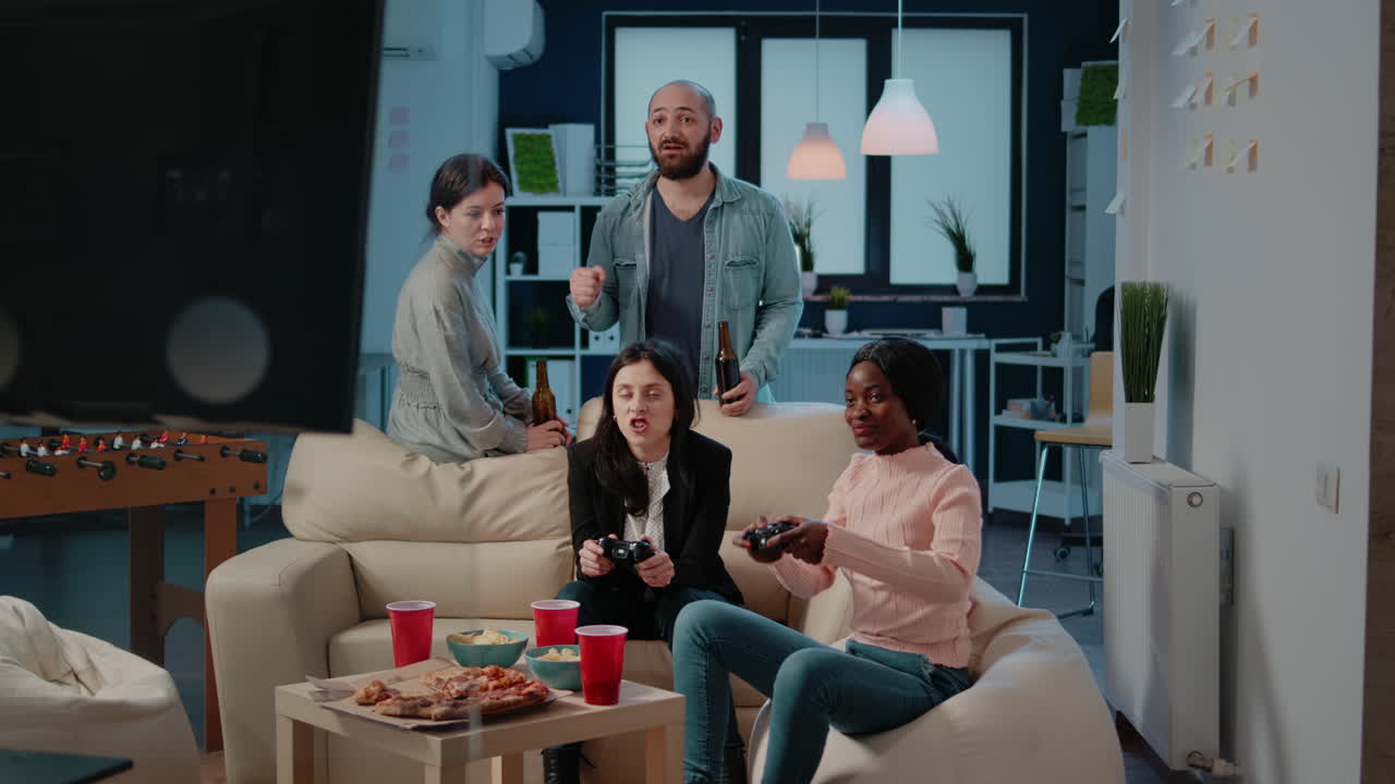 Colleagues playing video games on console with controller