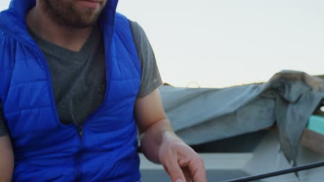 hombre atando el cebo en la caña de pescar 4k