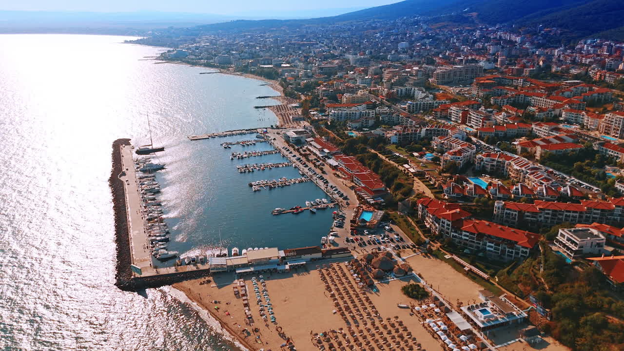 Sunny beach at famous resort and yacht club nearby. Aerial perspective on the scenery of Sveti Vlas on the mountain slopes