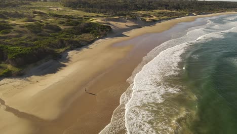 Toma-Aérea-En-órbita-Del-Hombre-En-La-Playa-De-Arena-Que-Se-Extiende-Frente-Al-Océano-Atlántico---Hermoso-Paisaje-Con-Dunas-En-Uruguay-Al-Atardecer