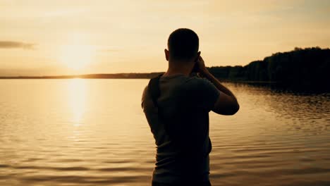 photographer silhouette at sunrise. beautiful summer sunset by the river