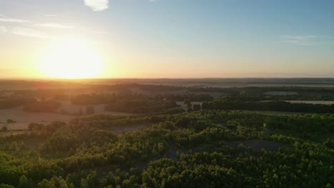 slow aerial drone shot of beautiful sunrise over trees and fields in kent