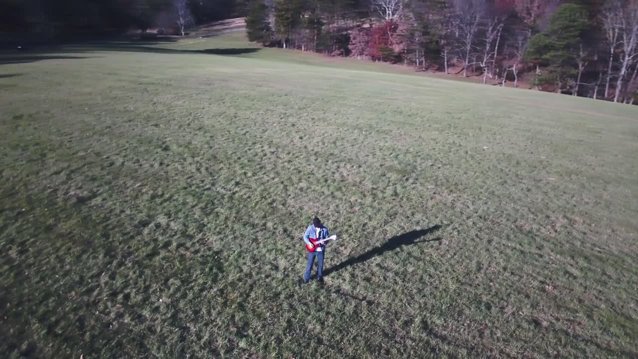 Man playing guitar in a field