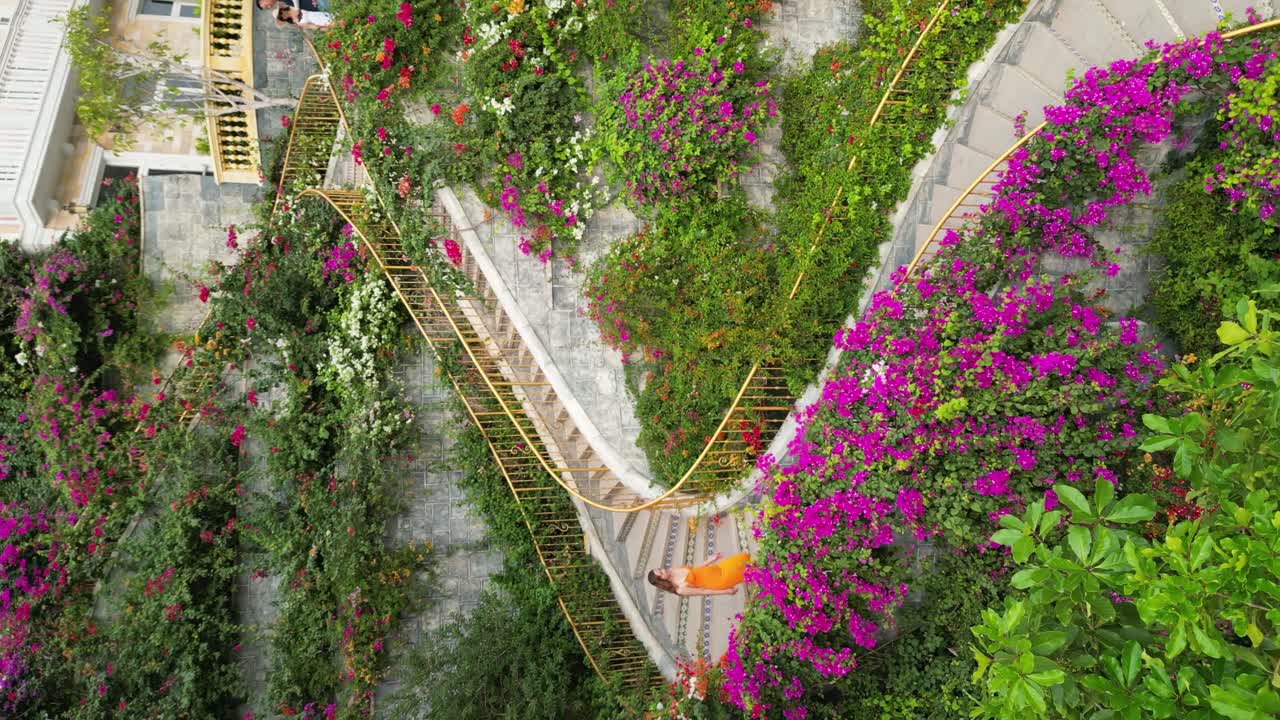 Aerial shot of a model walking down the dragon stairs in sunset town, Vietnam