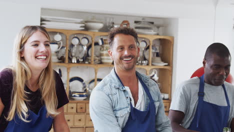 Male-And-Female-Adult-Students-Taking-Part-In-Cookery-Class-In-Kitchen