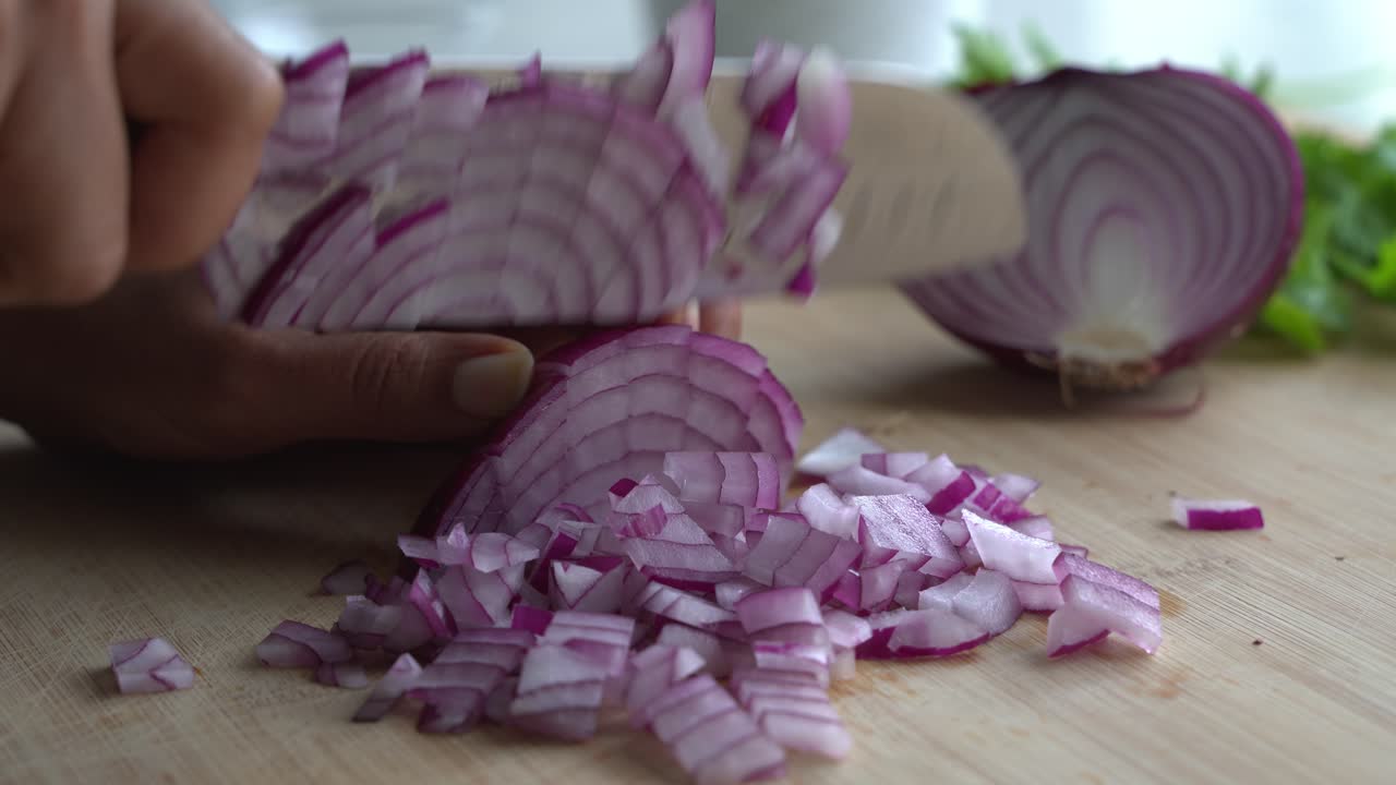 Slicing red onions into pieces and special ingredients to cook a meal two cans of beans rice plantain avocado red onion and cilantro