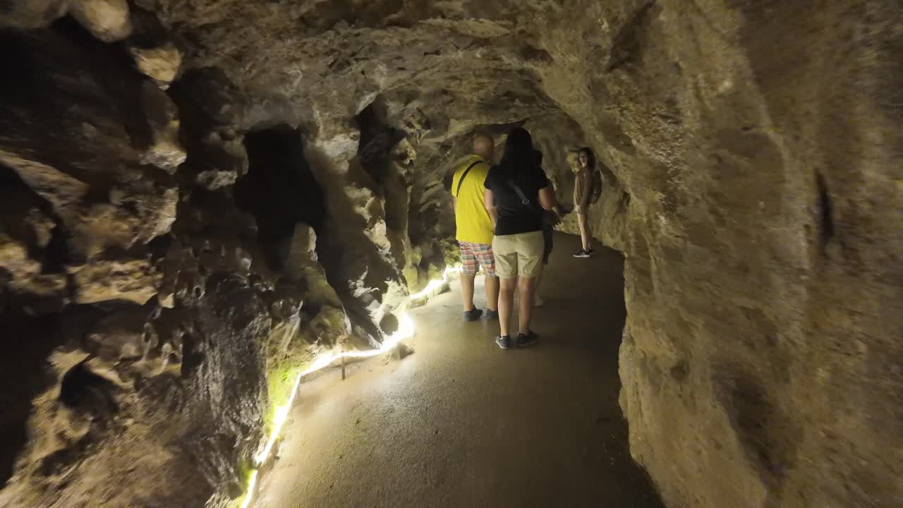 Golden rock textures in Sintra's Quinta da Regaleira cave, Portugal, dim lighting enhances mystery