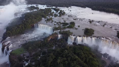 aerial-view-of-the-Iguazu-Falls-on-the-border-of-Argentina-and-Brazil-at-sunset,-flying-towards-the-main-waterfalls-Garganta-del-Diablo