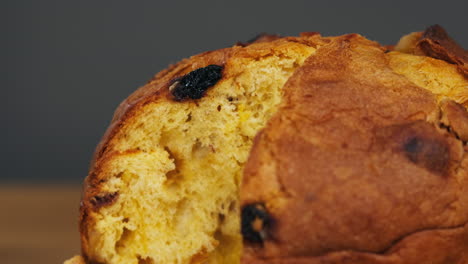 traditional english christmas cake tied with a jute thread on the black background. italian classic panettone .pastry chef sprinkles powdered sugar through a sieve on the fruit easter cake with raisins. high quality 4k footage