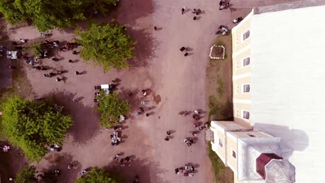 wide drone shot flies over the street market, whilst it reveals the crowd of people coming out from the moravian church.