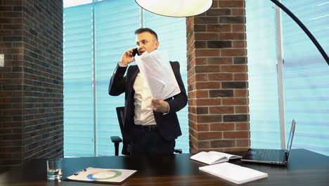 angry businessman throwing papers in office. young businessman throwing some paper sheets in the air