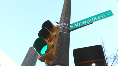 a stoplight with a street sign attached to it in the city