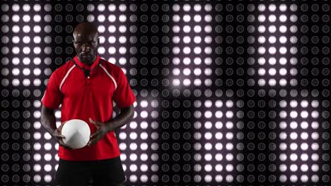 jugador de rugby profesional sosteniendo una pelota frente a una pantalla digital