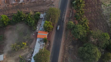 Dron-Siguiendo-El-Coche-De-Inova-Desde-Arriba-En-La-Carretera-De-La-Granja-De-La-Aldea-Rural-Cinemática-En-La-Puesta-Del-Sol-Amanecer-Maharashtra-India-Osmanabad