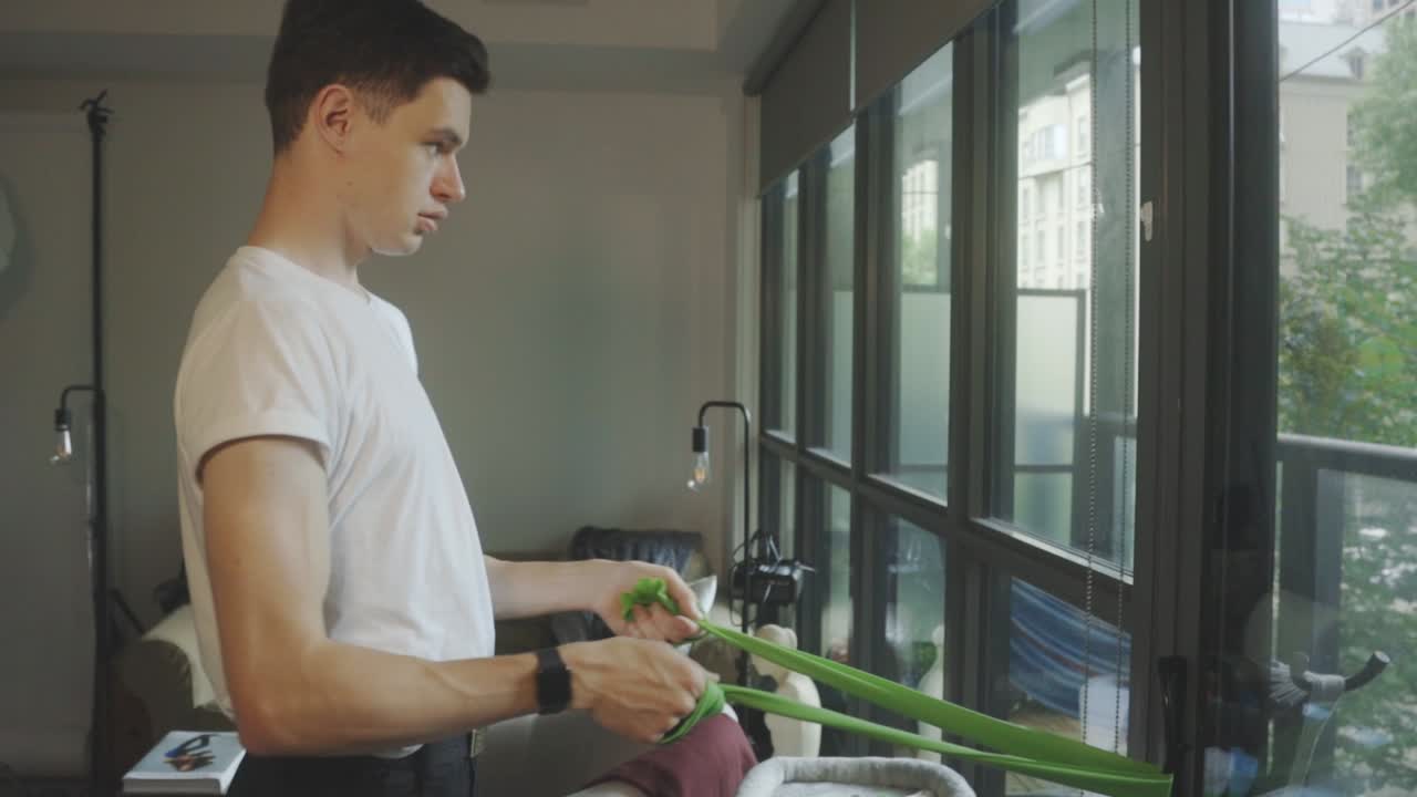 문 앞에 서 있는 한 남자의 반신체  ⁇ 이 가테르를 사용하여 팔을 펴고 있습니다.