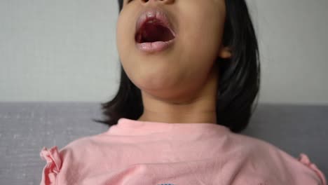 a close up portrait of a young girl smiling with her mouth open