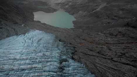 aerial flight over the gauli glacier in the bernese oberland region of the swiss alps with a panning view from the ice crevasses towards the glacial lake