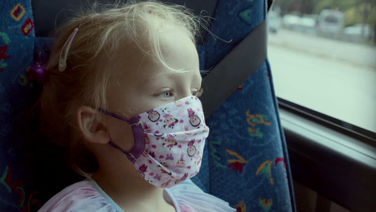 Small girl traveller yawning in a mask