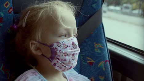 small girl traveller yawning in a mask