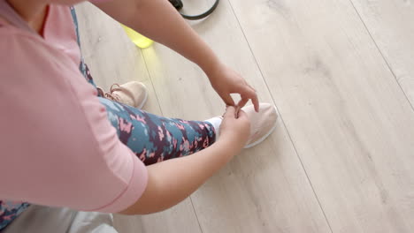 ángulo alto de talla plus mujer biracial atando zapatos deportivos antes de hacer ejercicio, copia espacio, cámara lenta