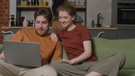 girl and boy watching videos with laptop while their female roommate cleaning the house 1