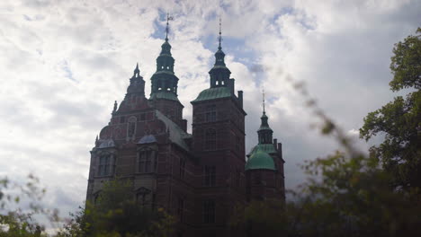 Admire-Rosenborg-Castle-against-a-cloudy-sky,-with-enchanting-gardens-and-historic-elegance