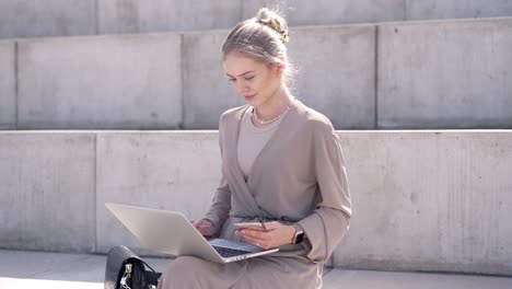 frau arbeitet im freien mit laptop und smartphone